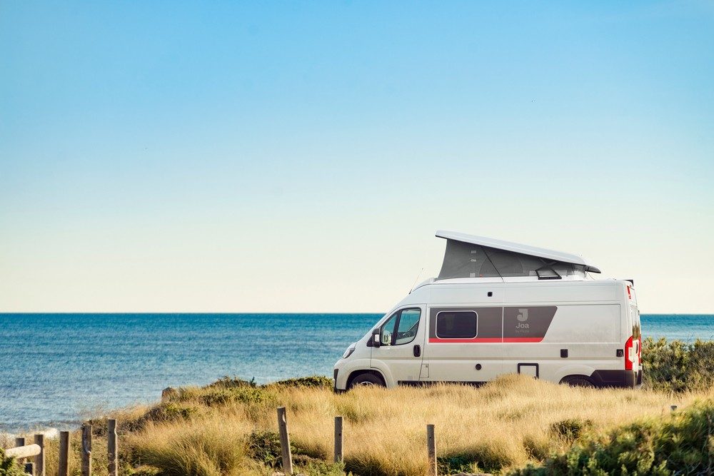 Camper van with roof top tent camp on beach