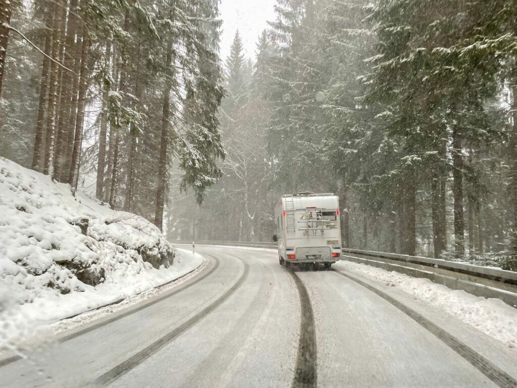 Un camping-car sur une route enneigée.